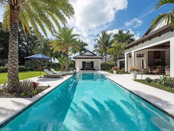 a view of house with yard and swimming pool