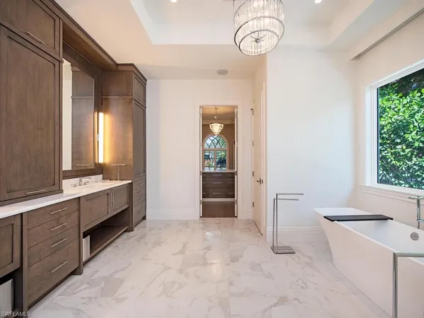 a large spacious bathroom with a double vanity sink a large mirror and a bathtub