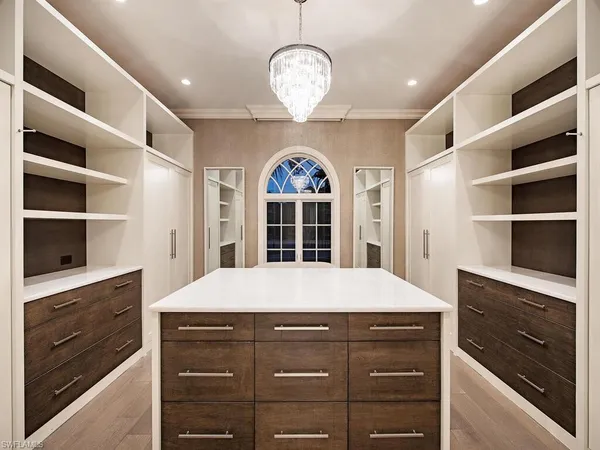 a spacious bedroom with a bed and a chandelier