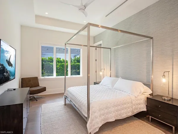 a bedroom with a bed and large window