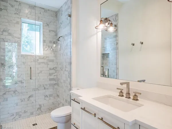 a bathroom with a sink a toilet and shower