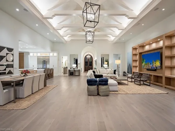 a living room with furniture a flat screen tv and kitchen view