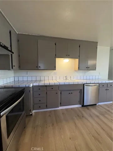 a large kitchen with granite countertop a stove top oven sink and cabinets