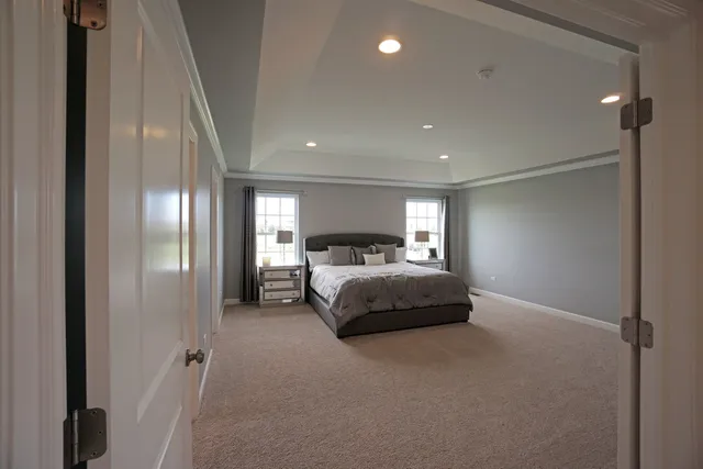 a spacious bedroom with a bed and a chandelier