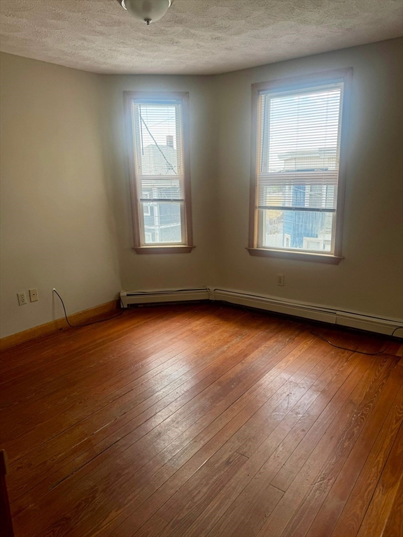 68 Maverick Street Chelsea, MA 02150 - Photo 11 of 16 an empty room with wooden floor and windows