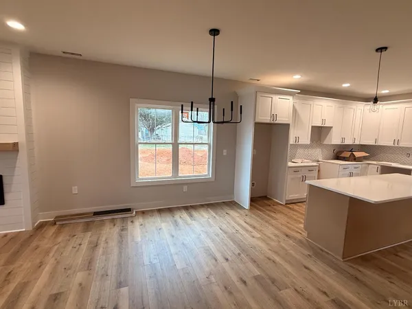 a kitchen with stainless steel appliances granite countertop a refrigerator a sink dishwasher a stove and white countertops with wooden floor