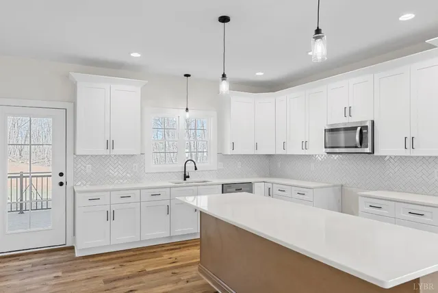 a kitchen with stainless steel appliances granite countertop a sink a stove and a refrigerator