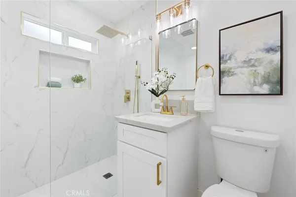 a bathroom with a sink a toilet and shower
