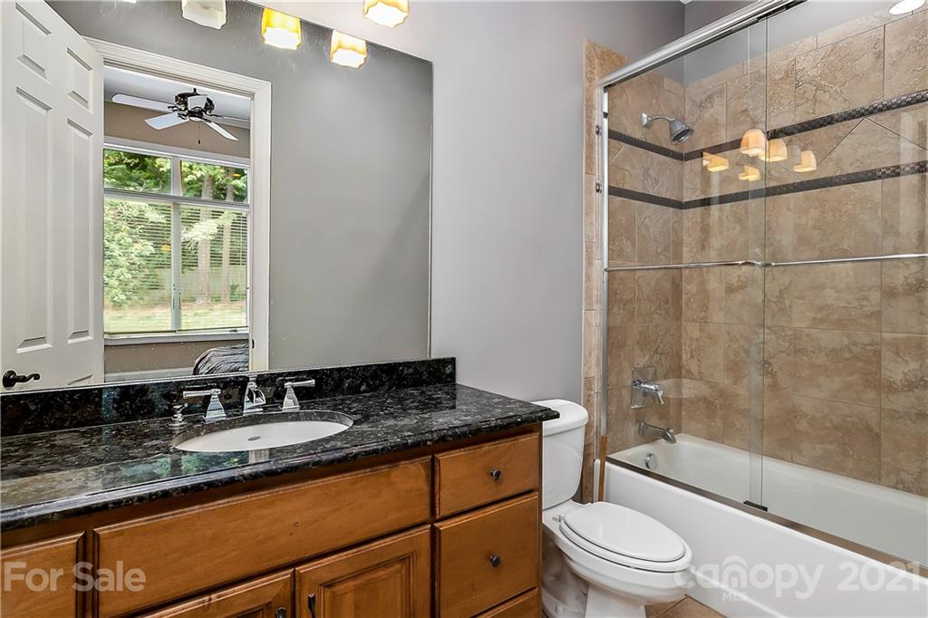 8891 Graham Point Lane Denver, NC 28037 - Photo 15 of 37 a bathroom with a granite countertop sink a toilet a mirror and shower