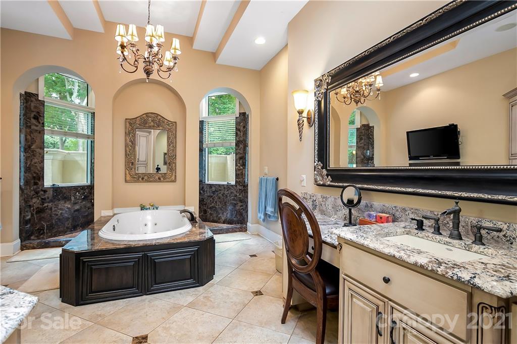 8891 Graham Point Lane Denver, NC 28037 - Photo 21 of 37 a spacious bathroom with a granite countertop tub a double vanity sink a chimney and a bathtub