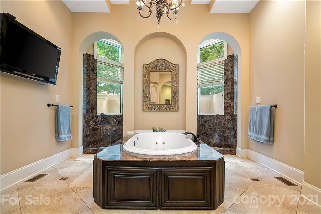 8891 Graham Point Lane Denver, NC 28037 - Photo 22 of 37 a bathroom with a granite countertop sink a large mirror and a bathtub
