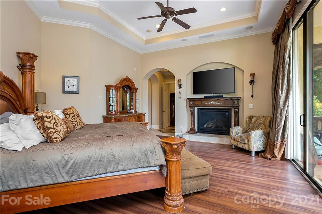 8891 Graham Point Lane Denver, NC 28037 - Photo 27 of 37 a bedroom with a bed and a fireplace