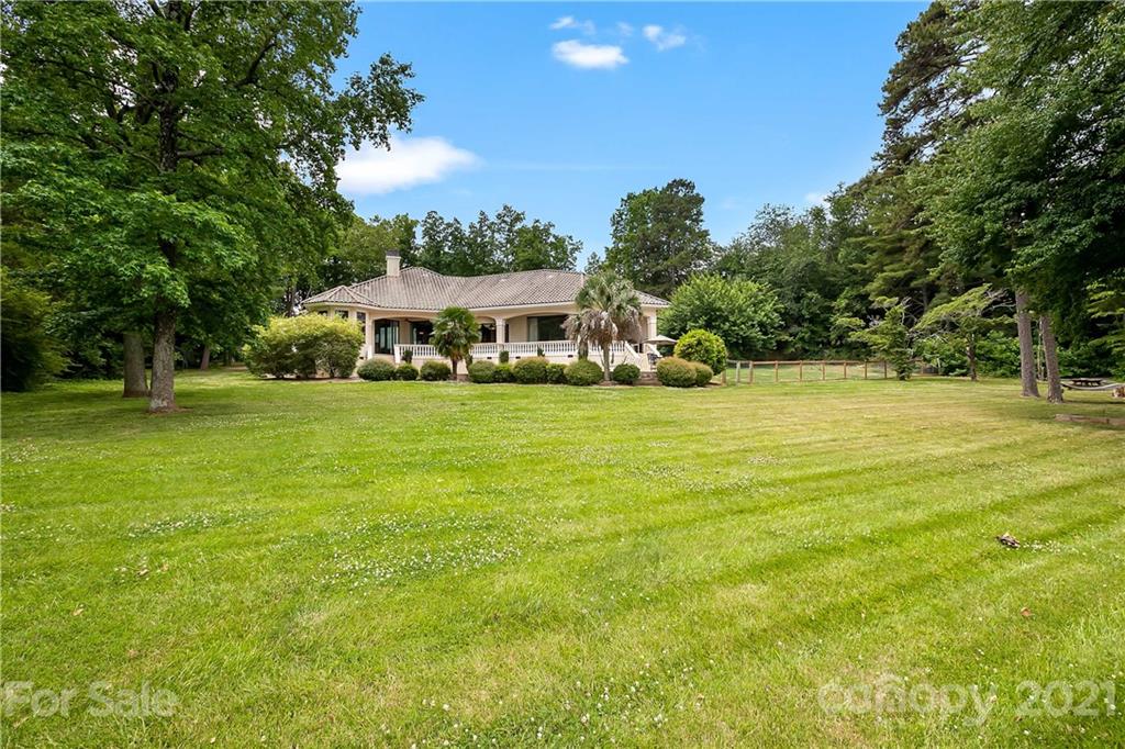 8891 Graham Point Lane Denver, NC 28037 - Photo 34 of 37 a view of a swimming pool with lawn chairs and large trees