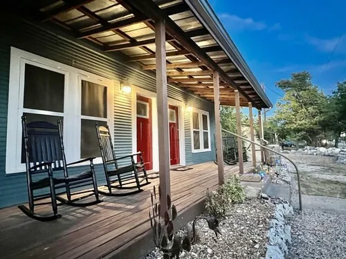 a backyard of a house with barbeque oven table and chairs