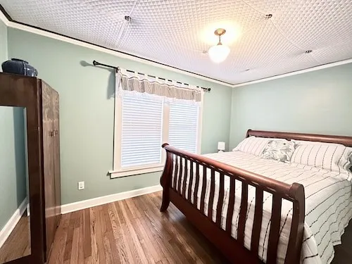 a bedroom with a bed and wooden floor