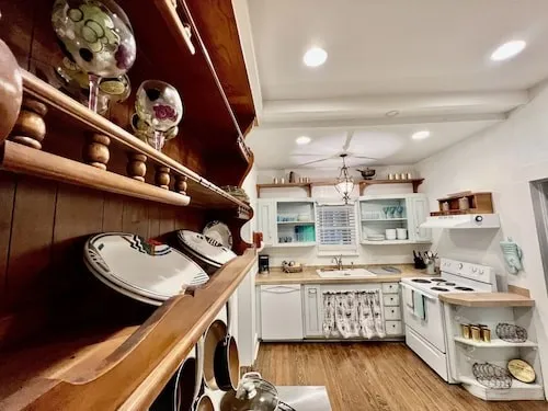 a kitchen with a stove and wooden floor