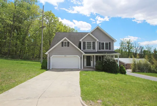 a front view of a house with yard and green space