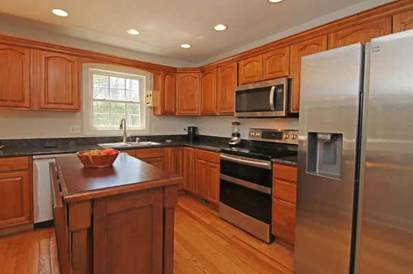 a kitchen with stainless steel appliances granite countertop a refrigerator sink and microwave
