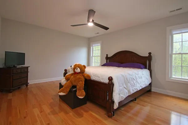 a bedroom with a bed and wooden floor
