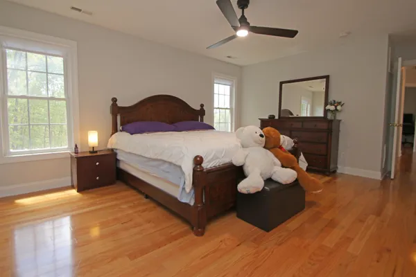 a bedroom with a bed and wooden floor