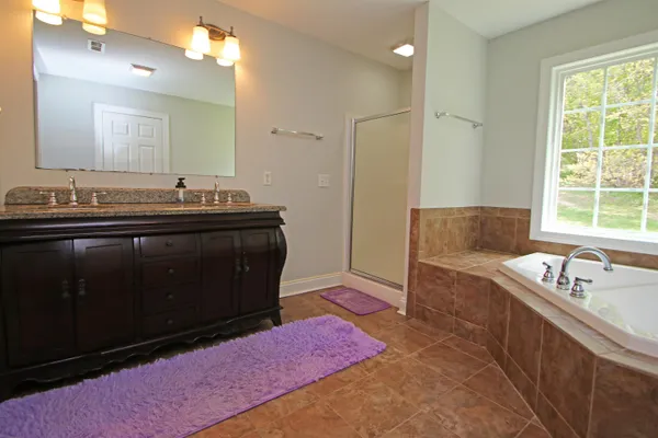 a bathroom with a bathtub sink and mirror