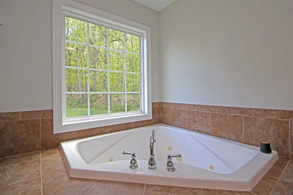 a bath tub sitting in a bathroom next to a window