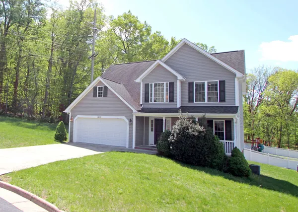 a front view of a house with a garden and yard
