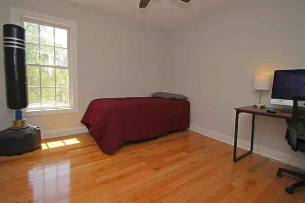 a bedroom with a bed and wooden floor