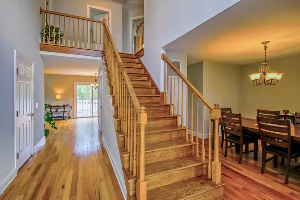 a view of a hallway with wooden floor and staircase