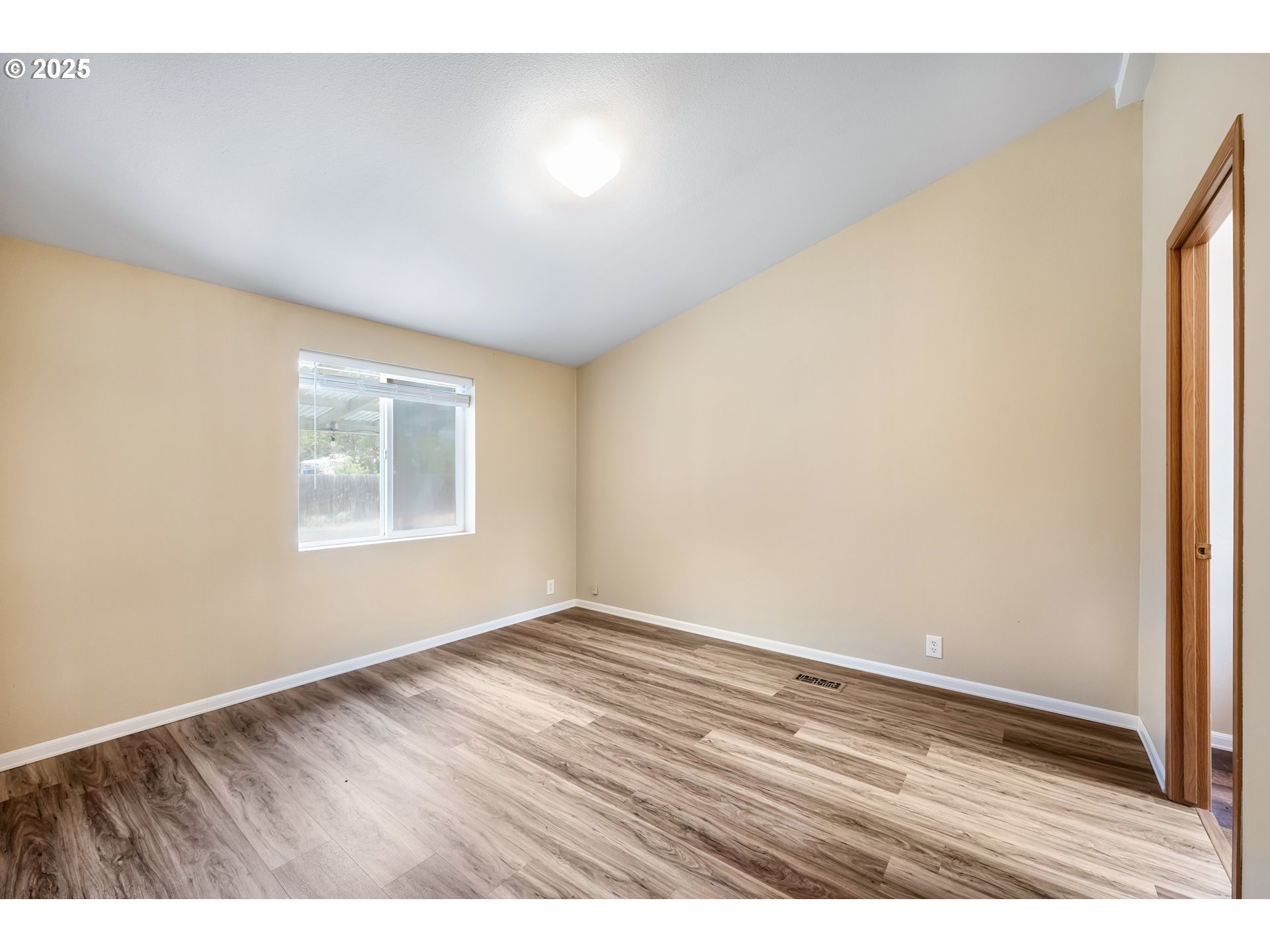 16173 North Drive La Pine, OR 97739 - Photo 3 of 23 a view of an empty room with wooden floor and a window