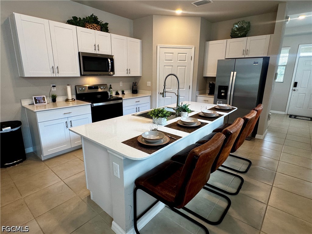 882 Friendship Circle LaBelle, FL 33935 - Photo 14 of 37 a kitchen with stainless steel appliances a stove a sink a microwave and a refrigerator