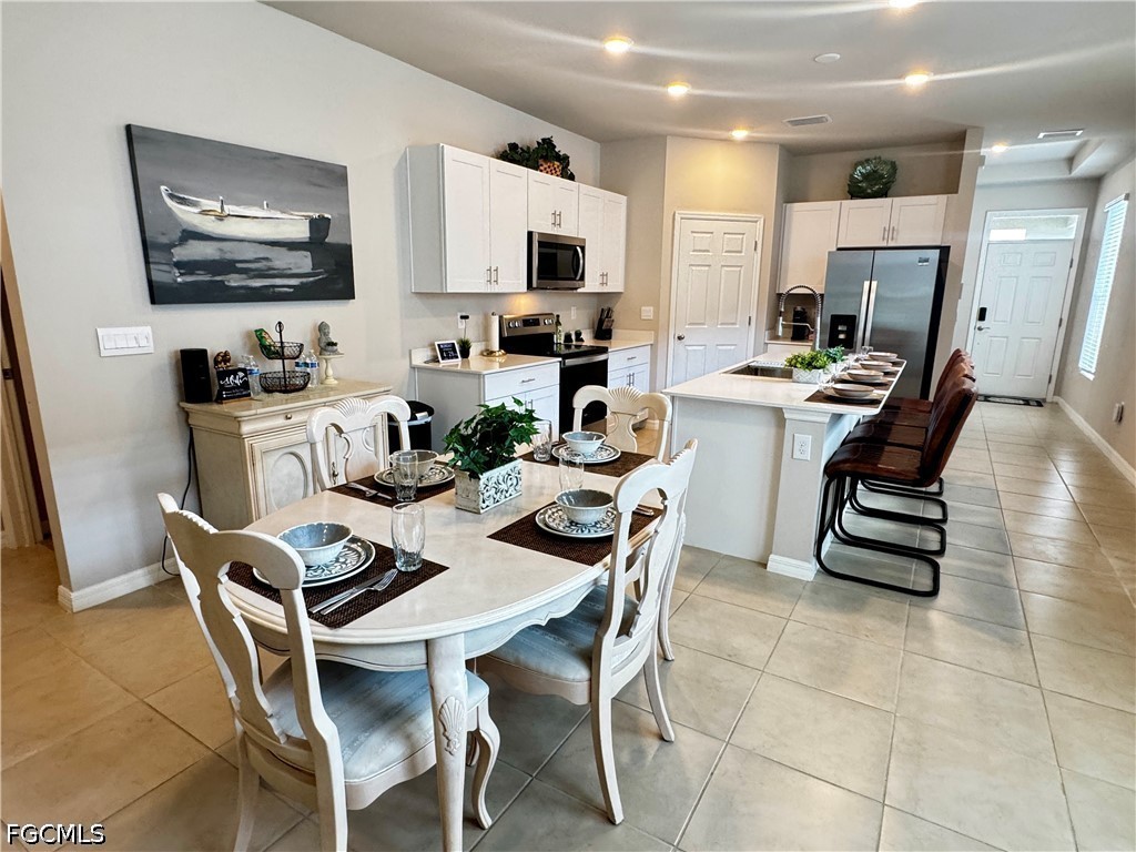 882 Friendship Circle LaBelle, FL 33935 - Photo 15 of 37 a kitchen with stainless steel appliances kitchen island granite countertop a sink a stove a dining table and chairs
