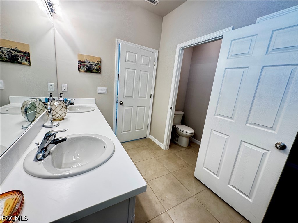 882 Friendship Circle LaBelle, FL 33935 - Photo 23 of 37 a bathroom with a sink a toilet and a mirror