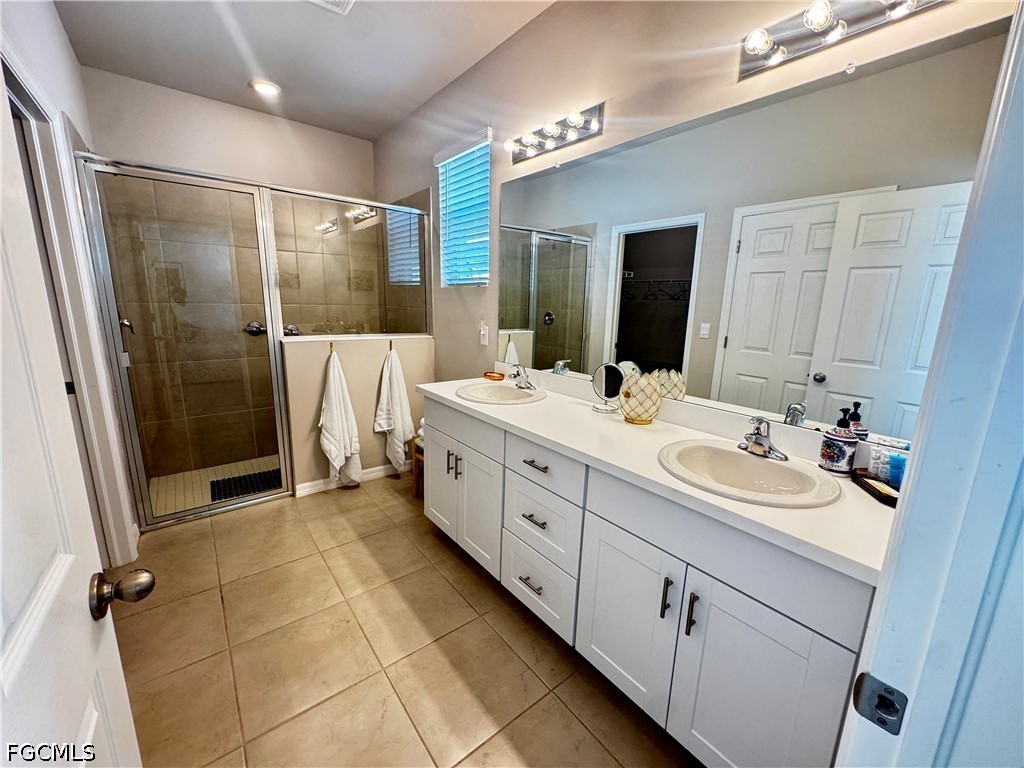882 Friendship Circle LaBelle, FL 33935 - Photo 5 of 37 a bathroom with a double vanity sink a mirror and a shower