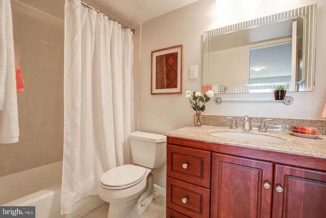 a bathroom with a granite countertop toilet sink and mirror