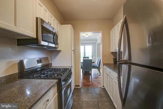 a kitchen with stainless steel appliances granite countertop a stove a refrigerator and a microwave