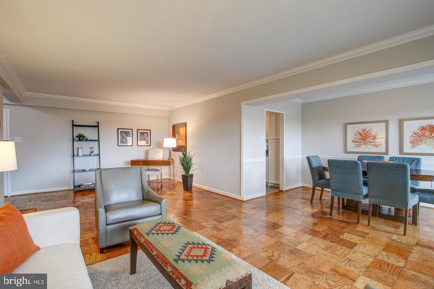 4201 Cathedral Avenue Northwest, Unit 1223E Washington, DC 20016 - Photo 9 of 26 a living room with furniture and a dining table with wooden floor