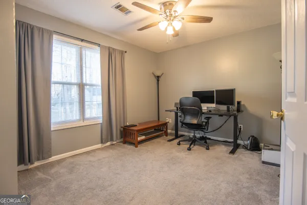 a view of a workspace with furniture and a window