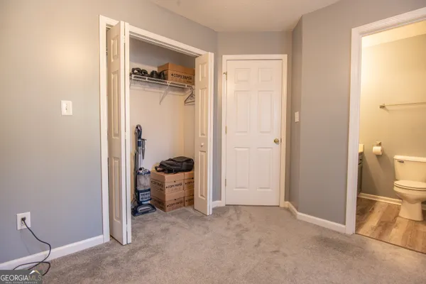 a view of a hallway with bathroom and a sink