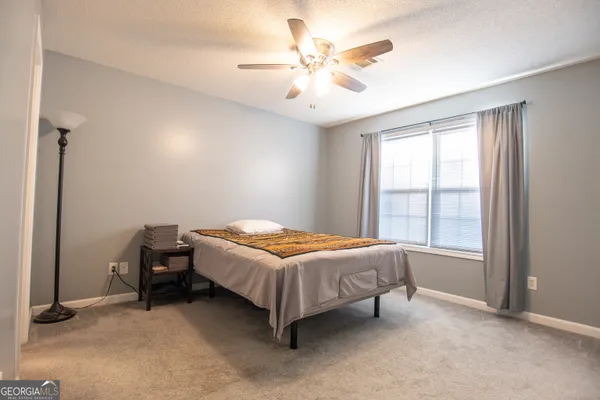 a room with a bed and a ceiling fan