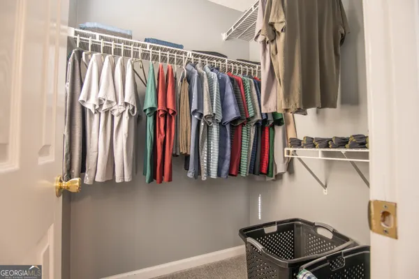a view of walk in closet with clothes and shoes