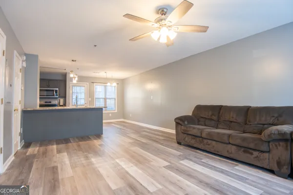 a living room with furniture and a ceiling fan