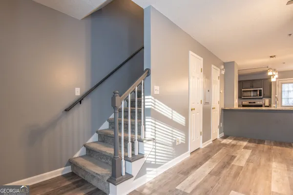 a view of a hallway with wooden floor and staircase