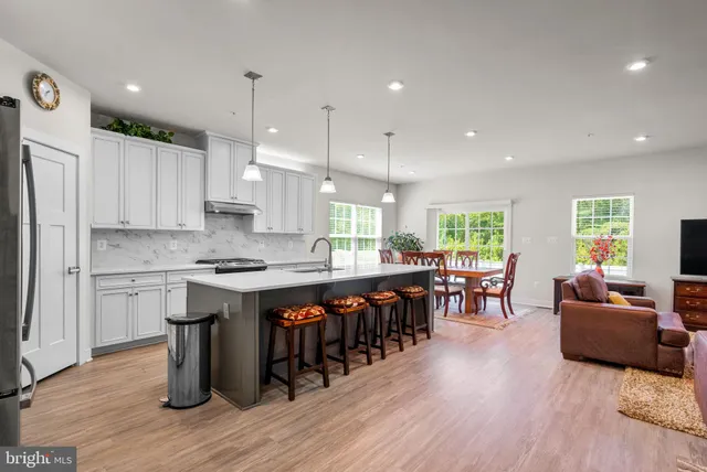 a kitchen with stainless steel appliances a refrigerator a sink and cabinets