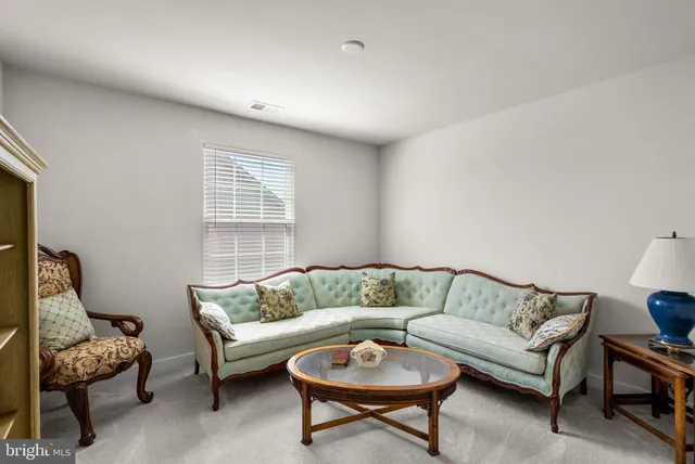 a large bedroom with a bed and a view of kitchen