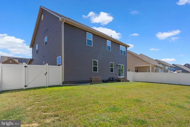 a view of a house with a yard and potted plants
