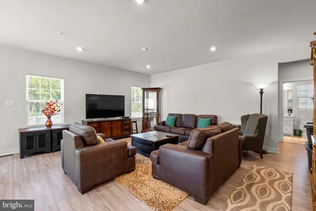 a living room with furniture kitchen view and a flat screen tv