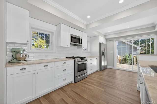 a large kitchen with granite countertop a sink and stove top oven