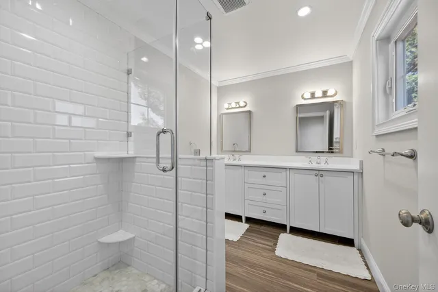 a bathroom with double vanity sink a mirror and a toilet