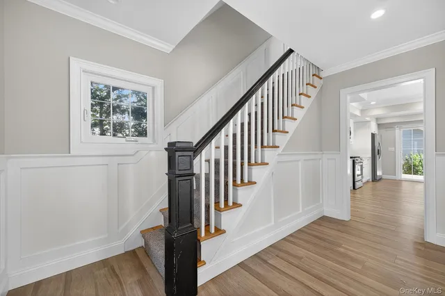 a view of staircase with wooden floor and white walls